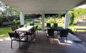 a wooden deck with a table and chairs on it at Huone lintukodossa in Helsinki