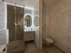 a bathroom with a shower and a toilet and a sink at The Minimalist Suite in Šurany