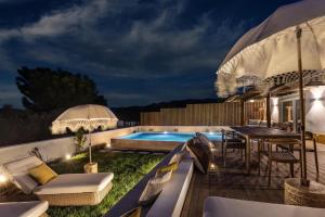 a backyard with a swimming pool at night at Herdade do Sobroso Wine Hotel & Villas - Small Luxury Hotels of the World in Pedrógão