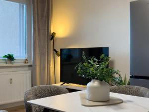 a living room with a table with a vase of flowers at The Minimalist Suite in Šurany