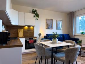 a kitchen and living room with a table and chairs at The Minimalist Suite in Šurany +13 photos