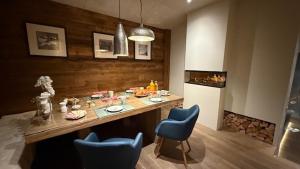 a kitchen with a table and blue chairs in a room at L'Orchidée in Sévrier