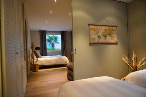 a bedroom with two beds and a map on the wall at L'Orchidée in Sévrier