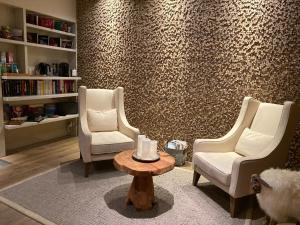 a living room with two chairs and a coffee table at L'Orchidée in Sévrier