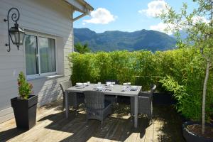 a table and chairs on a patio with mountains in the background at L'Orchidée in Sévrier