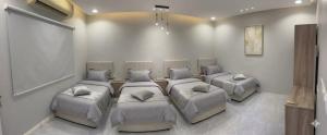 a room with four beds with pillows in it at فيلا ايمان مسبح وحوش وجلسات خارجيه مع ملعب كرة قدم in Taif +28 photos