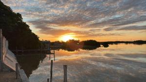 a sunset over a river with the sun setting at Flamingos Paraiso Chabihau in Chabihau