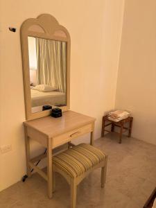 a wooden dressing table with a mirror and a stool at Flamingos Paraiso Chabihau in Chabihau