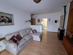 a living room with a gray couch and a kitchen at Casa Nonna Adelaide in Roncone