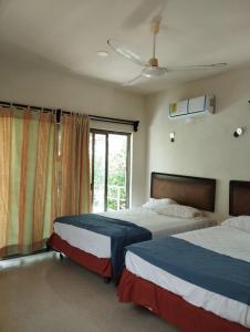 a bedroom with two beds and a window at Flamingos Paraiso Chabihau in Chabihau