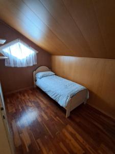 a bed in a small room with a wooden floor at Casa Nonna Adelaide in Roncone