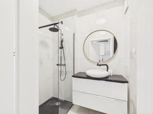 a white bathroom with a sink and a mirror at BelMare Seaside Apartment by Solarento in Międzyzdroje +4 photos