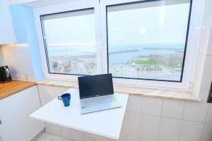 a laptop on a counter in a kitchen with a window at Três Sardinhas in Vila Praia de Âncora +5 photos