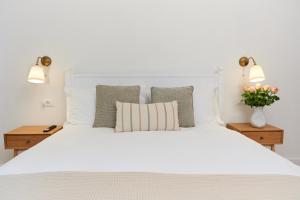 a bedroom with a large white bed with two lamps at TORTORELLA Apartments in Gorizia