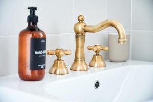 a bottle of soap next to a bathroom sink at TORTORELLA Apartments in Gorizia +38 photos