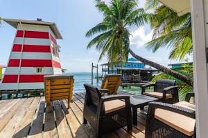 a deck with chairs and a lighthouse on the water at Faro del Colibri in Bocas Town