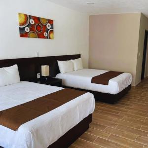 a hotel room with two beds and a painting on the wall at Hotel Ejecutivo Aeropuerto in Álvaro Obregón