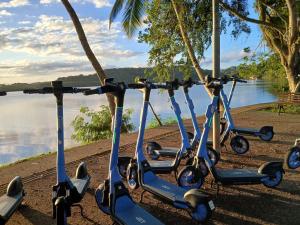 a row of scooters parked next to a body of water at Privileg in Ilhéus