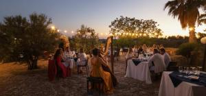 a group of people sitting at tables at a party at Agriturismo Tenuta La Siesta in Gallipoli