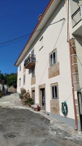 a white building with a balcony on the side of it at Casa de Mucha in Camariñas