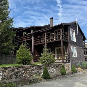 a large wooden house with a porch at Парк-готель Щастя in Skhidnitsa