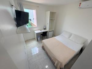 a bedroom with a bed and a desk and a television at Belaris HOTEL EXECUTIVO - Próximo a Praia do Calhau in São Luís +59 photos