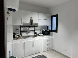 a kitchen with white cabinets and a sink at Voyage d'affaires et séjour paisible in Abidjan +15 photos