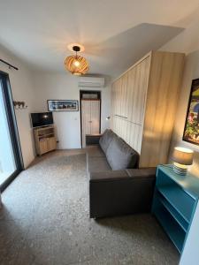 a living room with a couch and a television at Studio l'Enchantement in La Ciotat