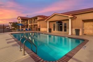 a swimming pool in front of a house at Best Western Dos Rios in Junction