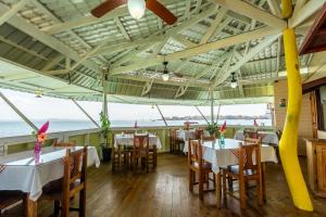 a restaurant with tables and chairs with the ocean in the background at Faro del Colibri in Bocas Town