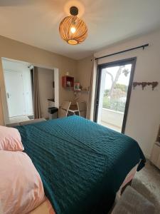 a bedroom with a large bed with a green blanket at Studio l'Enchantement in La Ciotat
