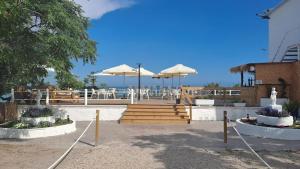 a patio with umbrellas and a table and chairs at bahia montecarlo in Les Cases d'Alcanar