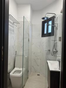 un bagno con WC e doccia in vetro di Tranquilité et confort comme à la maison a Abidjan