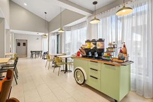 a restaurant with a counter and chairs and windows at Spark by Hilton Bettendorf Quad Cities in Bettendorf