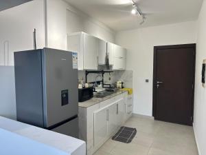 una cucina con mobili bianchi e un frigorifero di Tranquilité et confort comme à la maison a Abidjan Altre 29 foto