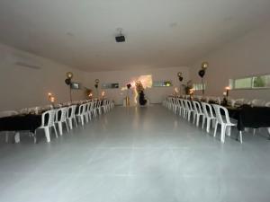 a banquet hall with tables and white chairs and candles at הוד והדר in Netanya