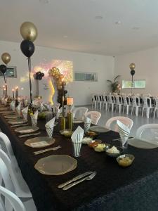 a long table with plates and utensils in a room with chairs at הוד והדר in Netanya