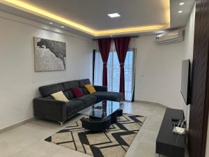 un soggiorno con un divano e un tavolo di vetro di Tranquilité et confort comme à la maison a Abidjan