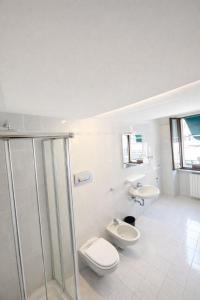 a white bathroom with a toilet and a sink at Vinessa Rooms in Sirmione +22 photos