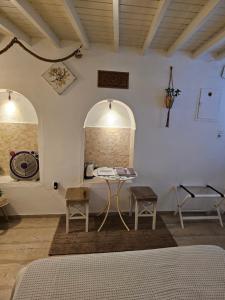 a room with a bed and a table and chairs at Capparis Studio in Mikonos