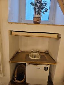 a tiny house with a window and two glasses on a shelf at Capparis Studio in Mikonos