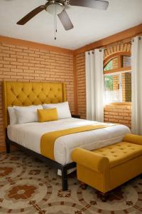 a bedroom with a large bed with a yellow headboard at Hotel Flamora-Valle de Guadalupe in Francisco Zarco