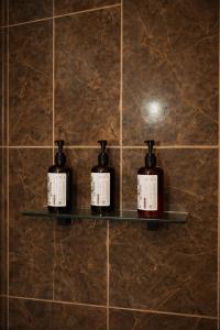 two bottles of soap on a shelf on a tiled wall at Hotel Flamora-Valle de Guadalupe in Francisco Zarco +32 photos