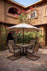 a table and two chairs under an umbrella at Hotel Flamora-Valle de Guadalupe in Francisco Zarco