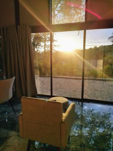 a living room with a chair and a large window at Villa Palladio Carrillo in Hojancha