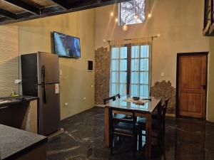 a kitchen with a refrigerator and a table with chairs at Manipa Loft 2 in Cafayate