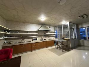 a large kitchen with a counter and a table at Payl Hotel in Arrinj