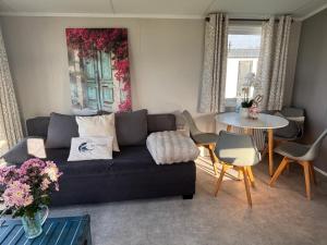 a living room with a couch and a table at NEU Chalet Wattenmeerblick 2026 in Westerland +18 photos