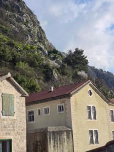 a house in front of a mountain at Nada's room with terrace in Kotor