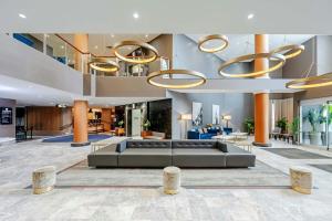 a lobby of a hotel with a couch and chairs at Sandman Signature Mississauga Hotel in Mississauga